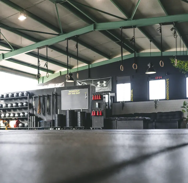 Trainingsfläche des Studios in Tübingen mit Hallendach, Gewichten und Gymnastikringen